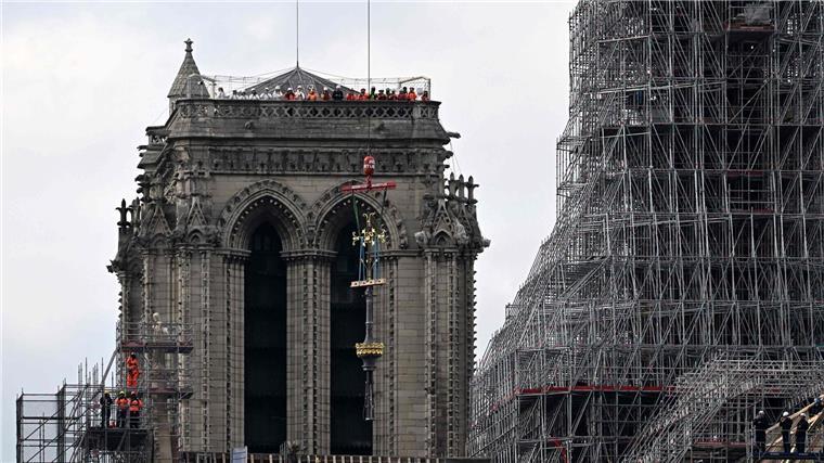 Protest gegen das Bleidach von Notre-Dame Das Kreuz der Kathedrale Notre-Dame wird während des Wiederaufbaus auf die neu errichteten Turmspitze gesetzt.