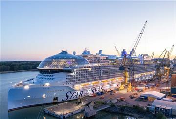 Das Kreuzfahrtschiff „Star of the Seas“ liegt zur Fertigstellung an der Meyer Turku Werft in Finnland, umgeben von Kränen und Werftanlagen bei Sonnenuntergang.