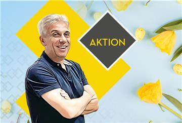 Freundlich lächelnder Mann mit verschränkten Armen steht vor der Aufschrift "Aktion"