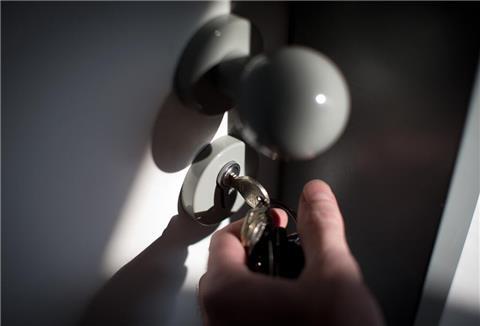  Ein Schlüssel steckt im Schloss einer Wohnungstür. 