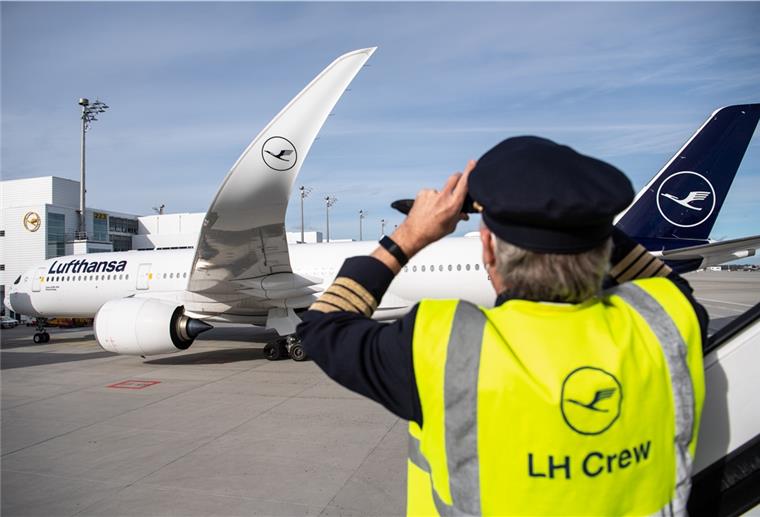 „Polarstern“-Team nach Rekordflug wieder zurück Ein Mann mit einer Weste mit der Aufschrift "LH Crew" fotografiert einen Airbus A350-900 nach der Landung nach dem längsten Nonstopflug in der Geschichte der Lufthansa auf dem Flughafen in München