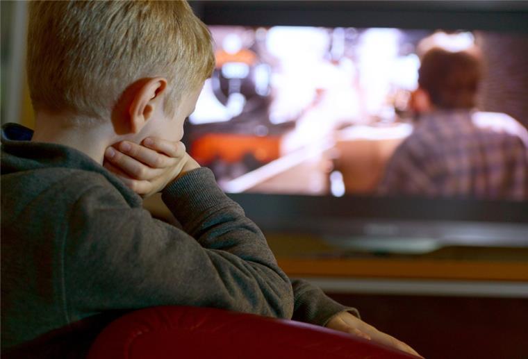 Ein Kind sitzt vor dem Fernseher.
