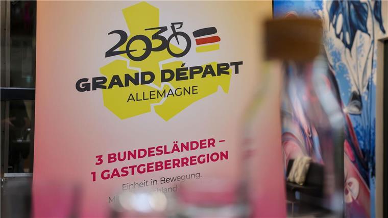 Tour-Auftakt 2030 im Osten? Streckenplaner weiß von nichts Das Logo für die Bewerbung zum geplanten Start der Tour de France 2030 in Ostdeutschland hängt auf einer Pressekonferenz.
