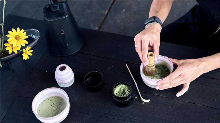 Das Matcha-Pulver wird mit Wasser und einem Besen schaumig geschlagen. 