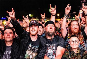 Festivalbesucher feiern vor einer Bühne die auftretenden Musiker. +++ dpa-Bildfunk +++