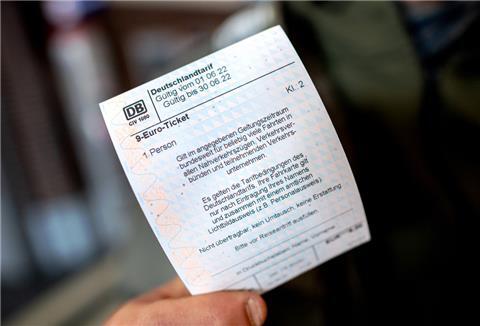  Ein junger Mann hält im Hauptbahnhof ein 9-Euro-Ticket der Deutschen Bahn in der Hand. 