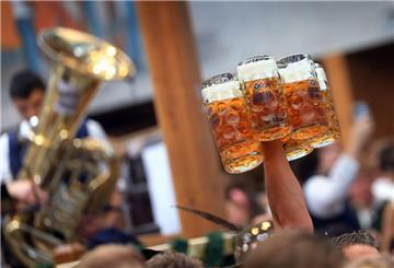 Eine Bedienung trägt im Hacker-Pschorr-Festzelt auf dem Oktoberfest mehrere Maßkrüge.
