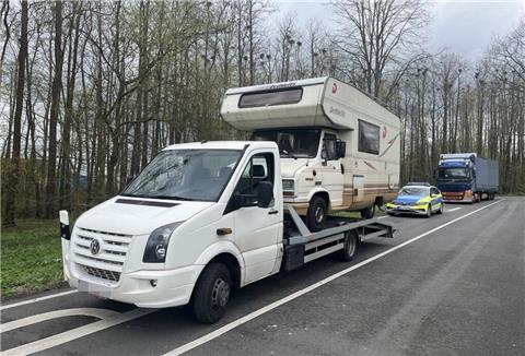 Transporter mit Wohnmobil auf der Ladefläche