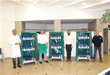 Das Projektteam zur Einführung des Mehrwegsystems präsentiert die neuen Transportwagen der Mehrwegflaschen. Foto: Privat