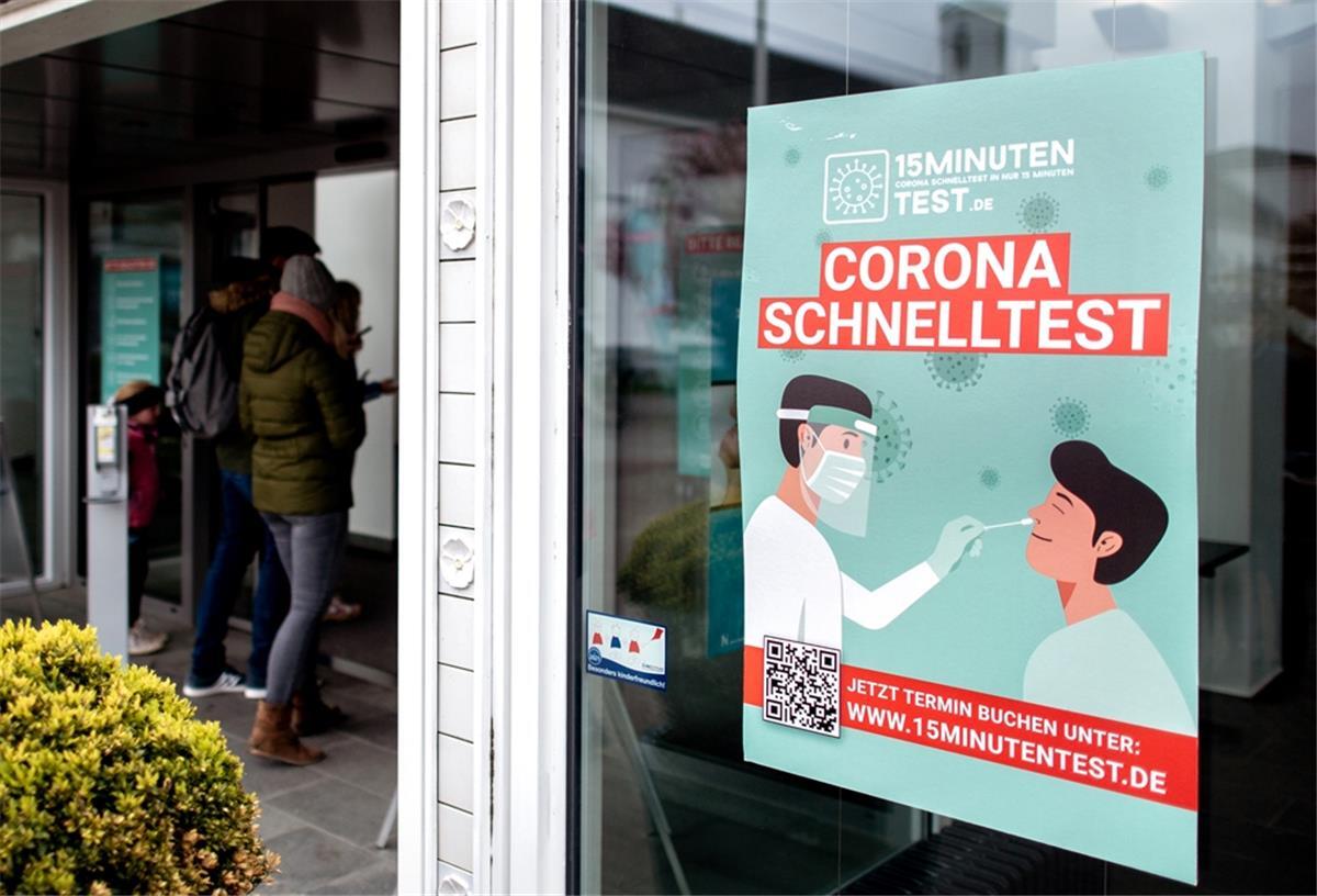 Ein Plakat mit der Aufschrift «Corona Schnelltest» hängt in einem Fenster des Badehauses am Kurplatz auf Norderney, in dem sich derzeit das Corona-Testcenter der Insel befindet. 
