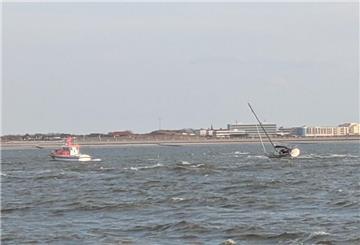 Eine Segelyacht wird bei stürmischem Wetter abgeschleppt