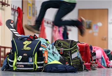 Ein Schüler der 2. Klasse der Robert-Schumann-Grundschule springt über abgestellte Schulranzen.