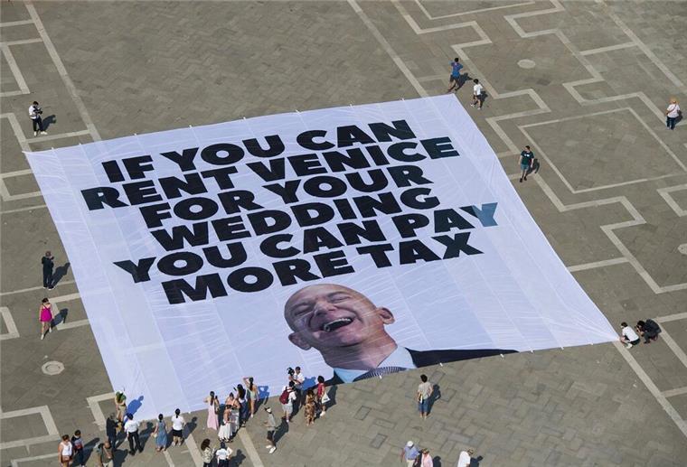 Amazon-Gründer Bezos und Braut zu Hochzeit eingetroffen Das Transparent zeigt ein Foto des Amazon-Gründers, auf dem steht: „If you can rent Venice for your wedding you can pay more tax“.