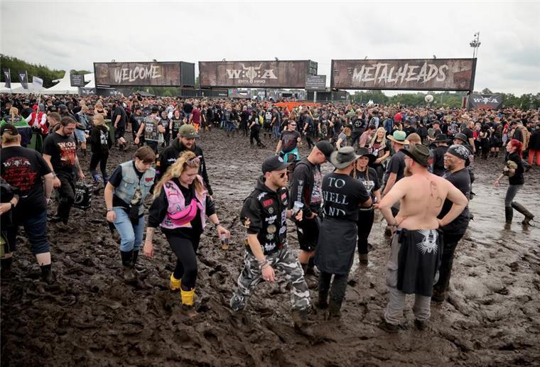 Metal-Fans warten an einem der Eingänge auf die Öffnung des Festivalgeländes.