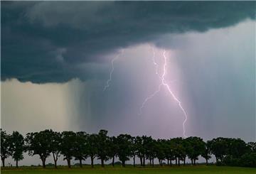  Ein Blitz leuchtet am späten Abend über der Landschaft. Das Wetter in Deutschland wird Richtung Wochenende deutlich schlechter. Örtlich drohen sogar Tornados.