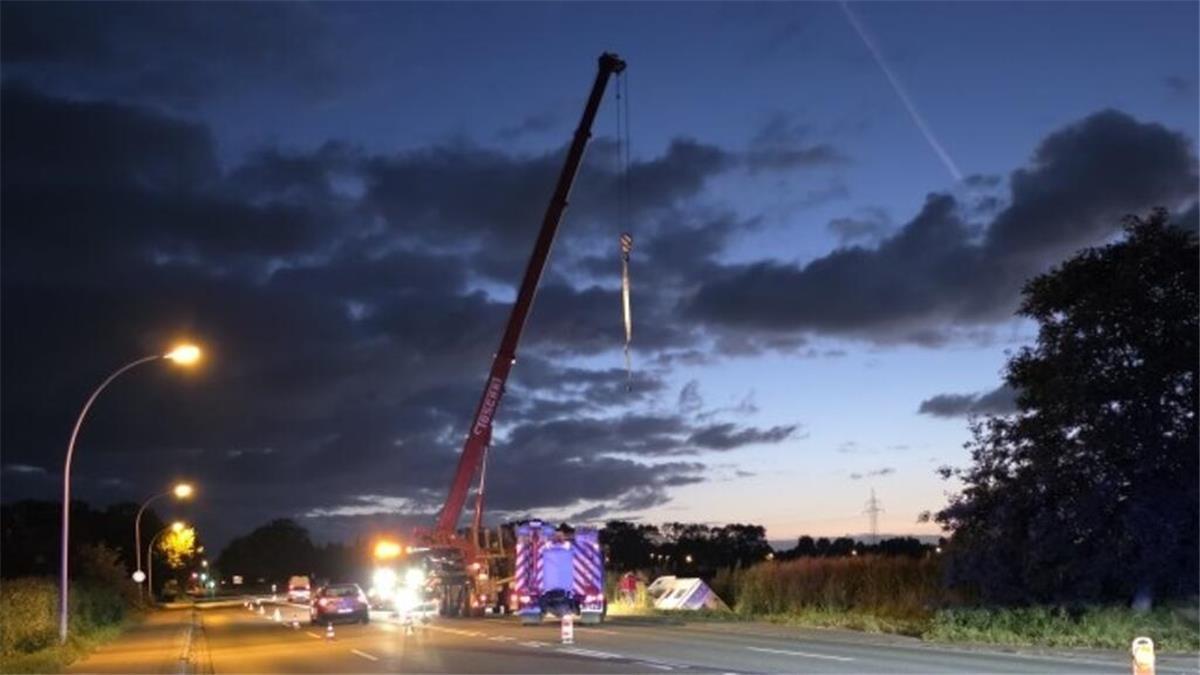 Sekundenschlaf: Nachtfahrt mit Wohnmobil in Cuxhaven endet in Graben Ein mobiler Kran steht am Rande einer Straße, davor ein Fahrzueg der Feuerwehr.
