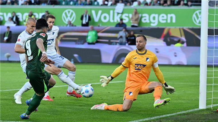 Das Wolfsburger Führungstor: Mohamed Amoura bringt den Ball in die Mitte, Leo Östigaard (l) trifft ins eigene Tor.