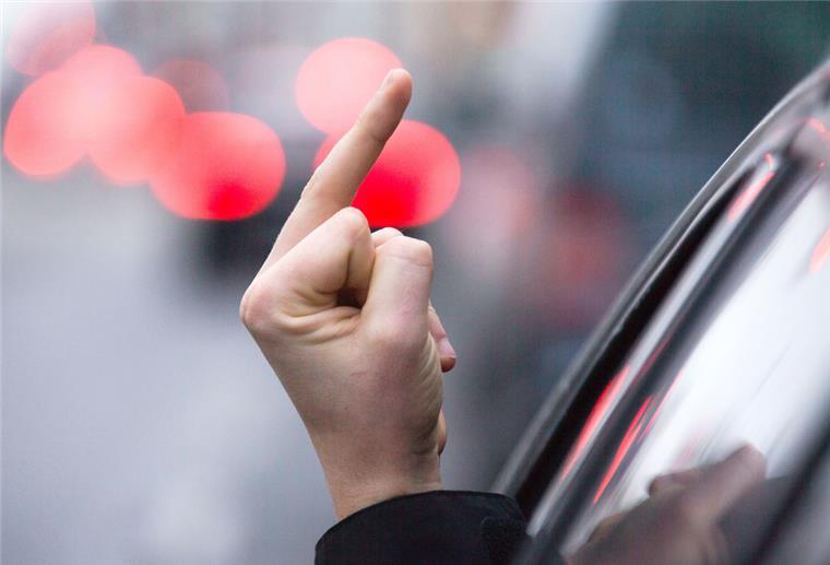 junger Fahrer zeigt Mittelfinger, natürliches Licht, selektiven