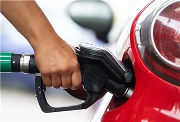 Ein Mann tankt an einer Tankstelle Benzin. An einer Autobahntankstelle ist der Preis für Sprit deutlich höher.