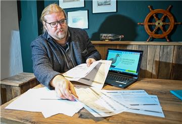 Christian Neuhäuser zeigt Datensätze zum Klimawandel in Bremerhaven auf Papier und am Laptop.