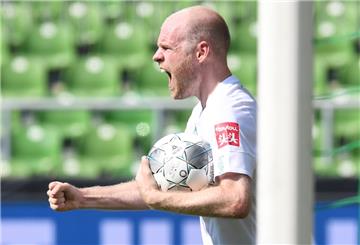 Mann mit Ball in der Hand und geballter Faust schreit.