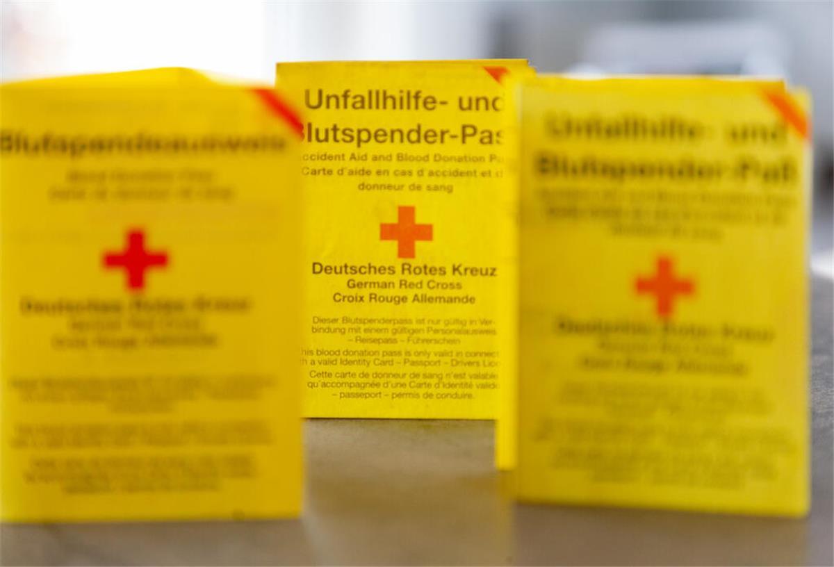 Drei Blutspendeausweise auf einem Tisch.