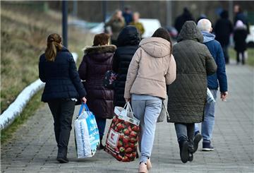 Ukrainische Flüchtlinge gehen die Straße entlang.