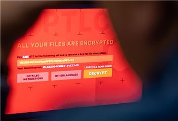 Ein Mann sitzt vor einem Laptop, der mit einem fiktiven Verschlüsselungstrojaner (Ransomware) befallen ist.