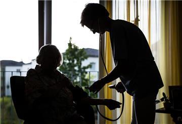23.08.2018, Baden-Württemberg, Stuttgart: Eine Pflegekraft kümmert sich in einem Pflegeheim um eine ältere Dame und kontrolliert den Blutdruck. Foto: Christoph Schmidt/dpa +++ dpa-Bildfunk +++