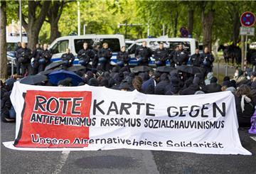 Demonstranten beteiligen sich mit einem Banner mit der Aufschrift "Rote Karte gegen Antifeminismus Rassismus Sozialchauvinismus - unsere Alternative heißt Solidarität" an einer Sitzblockade an einer Zufahrt zum Schützenplatz. In einem Zelt fand dort der Landesparteitag der AfD Niedersachsen statt.
