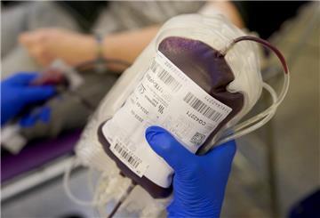 Eine Mitarbeiterin des Deutschen Roten Kreuzes (DRK) hält eine Blutspende in der Hand