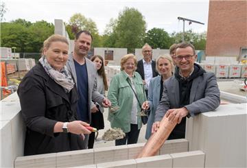 Den Grundstein für die neue Mensa der Heinrich-Heine-Schule haben am Freitag Schulleiterin Meike Ehler (links) und Dezernent Michael Frost (rechts) gelegt