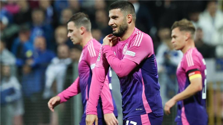 Deniz Undav (M) imitiert nach dem 2:0 die Jubelpose seines Stuttgarter Kollegen Ermedin Demirovic. Er streicht sich mit der Hand an der Schulter das Trikot glatt. 