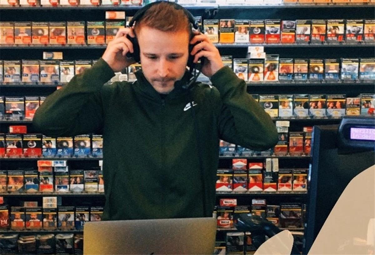 TSV Lunestedt: Dennis Heinemann reist in die Podcast-Welt Mann mit Kopfhörern steht in Kiosk vor Zigarrettenregal