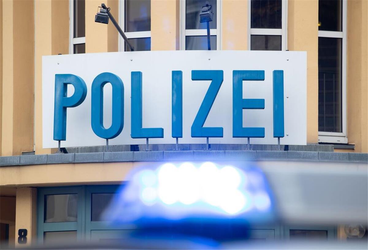 Ein Einsatzwagen der Polizei steht vor einer Dienststelle