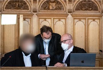 Der Angeklagte (l) sitzt vor Beginn des Berufungsverfahrens vor dem Bremer Landgericht im Gerichtssaal mit seinen Anwälten zusammen