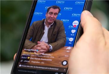 Ein Mann schaut sich auf dem TikTok-Account von der CSU einen Clip mit Parteichef und Ministerpräsident von Bayern, Markus Söder, auf seinem Smartphone an.