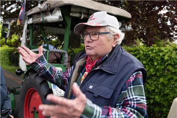 Der als "Deutz-Willi" bekannte Rentner Winfried Langner steht vor der Abfahrt an seinem Traktor. Er will mit seinem Deutz-Traktor Baujahr 1961 und seinem kleinen Wohnwagen nach Schottland. 