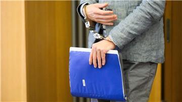 Polizistin im Prozess gegen Christian B. unter Druck Der Angeklagte Christian B. kommt in Handschellen und mit einem Aktenordner in der Hand in den Gerichtssaal.