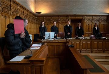 Der Angeklagte im Prozess wegen Mordes steht im Gerichtssaal.