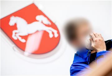 Ein Angeklagter sitzt vor Prozessbeginn in einem Gerichtssaal im Landgericht.
