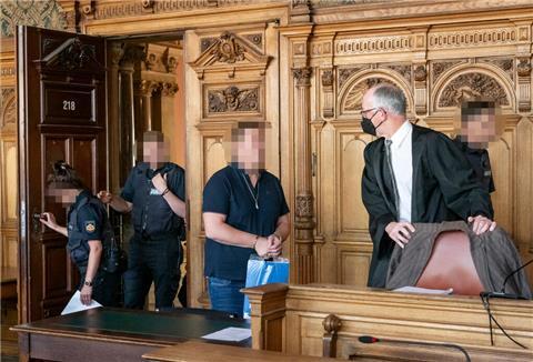 Der Angeklagte wird von Justizvollzugsbeamten in den Verhandlungssaal geführt.