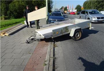 Ein beschädigter Anhänger steht vor einer Laterne und wird entladen. 