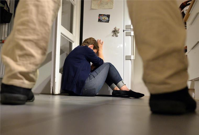  Gestelltes Bild zum Thema häusliche Gewalt - Eine Frau versucht, sich vor der Gewalt eines Mannes zu schützen. 