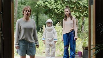 Zwei Frauen und ein kleiner Junge stehen in einer Tür. Der Junge ist als Astronaut verkleidet.