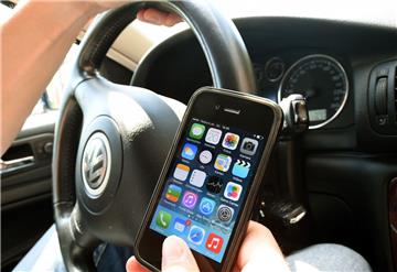 Der Autofahrer schaute während der Fahrt auf sein Handy.
