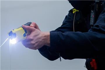 Ein Polizist schießt mit einem Taser.