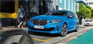 Blauer BMW 1er auf einer sonnigen Straße