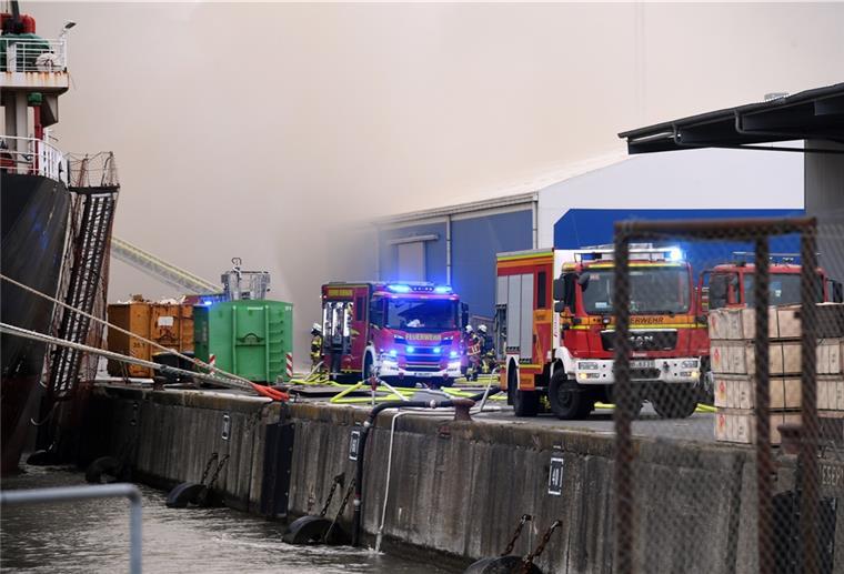 Der Brand auf dem Holzfrachter an der Heuer-Kaje ist unter Kontrolle. Allerdings muss die Feuerwehr wegen des Windes noch warten, bis sie einen weiteren Laderaum kontrollieren kann.