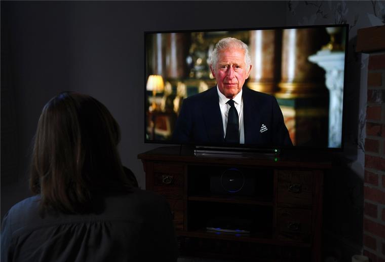 TV-Ansprache: König Charles wendet sich direkt an die Queen Eine Frau schaut auf einen TV-Bildschirm, auf dem König Charles III. zu sehen ist.